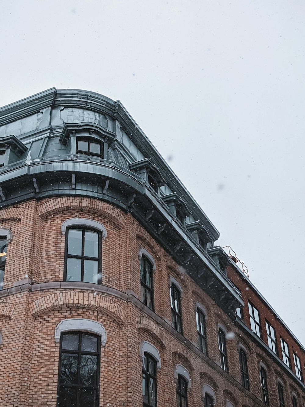 Edificio de hormigón marrón bajo el cielo blanco durante el día