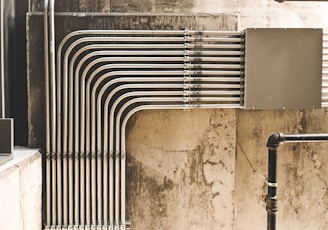 grey metal pipe on brown concrete wall