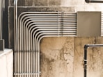 grey metal pipe on brown concrete wall