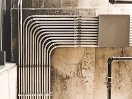 grey metal pipe on brown concrete wall