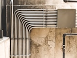 grey metal pipe on brown concrete wall