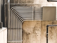 grey metal pipe on brown concrete wall