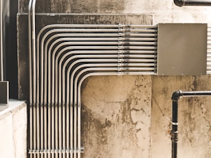 grey metal pipe on brown concrete wall