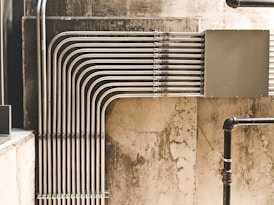 grey metal pipe on brown concrete wall