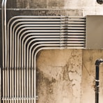 grey metal pipe on brown concrete wall