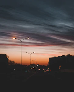 Technicians installing fiber optic cables along a city street at sunset.