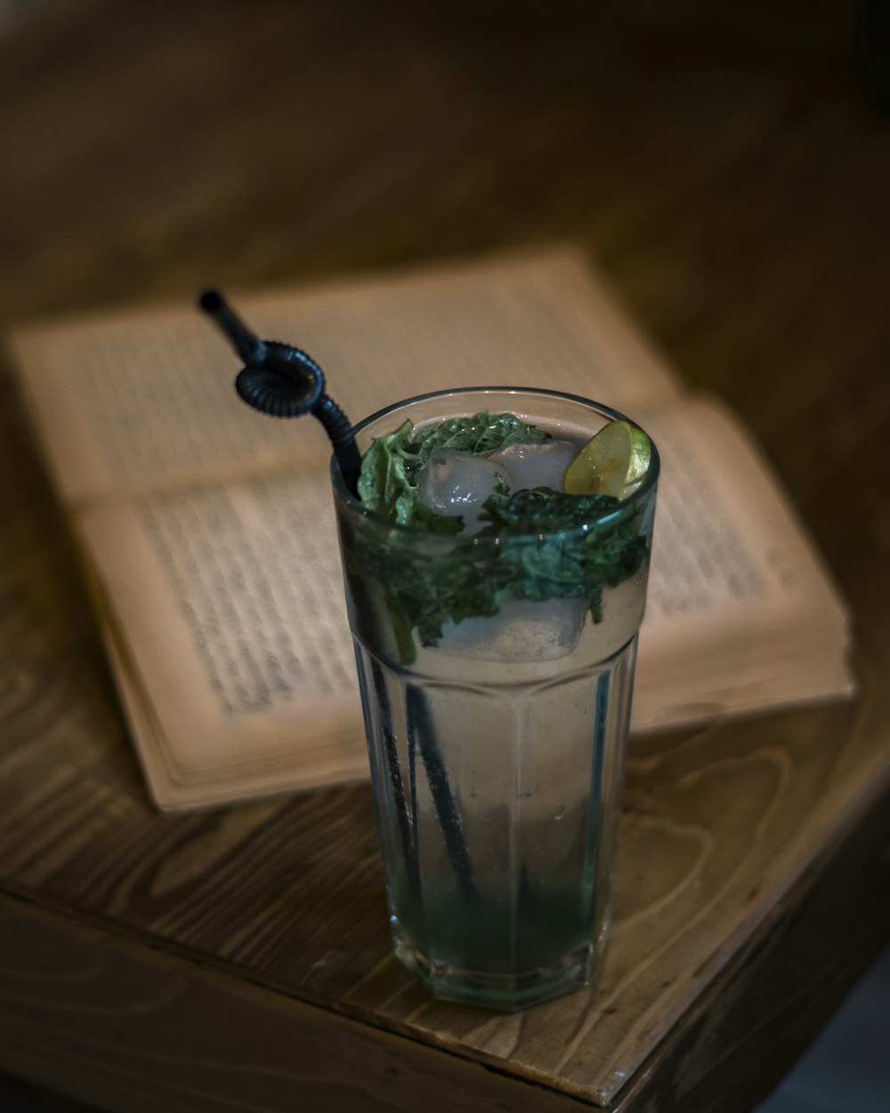 clear drinking glass with ice and black straw