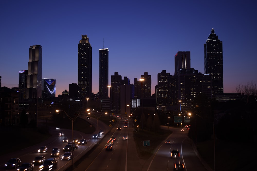 cars on road near city buildings during night time