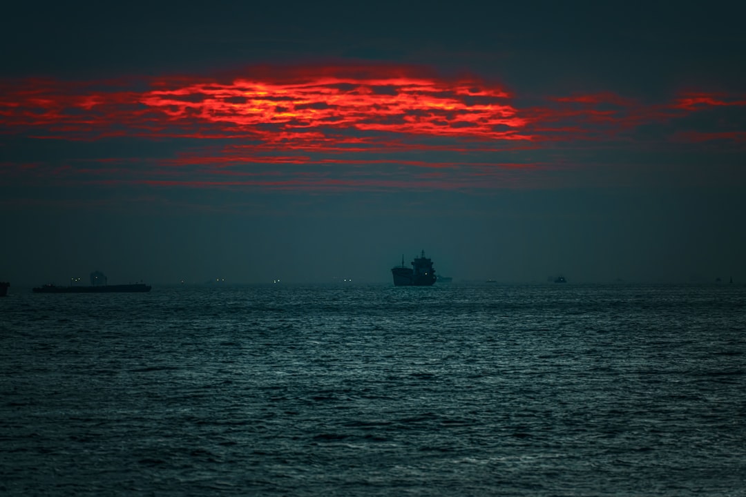 silhouette of boat on sea during sunset