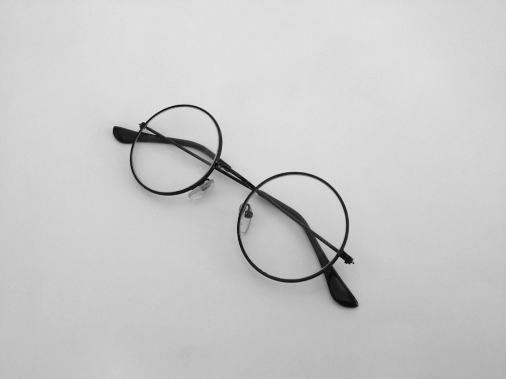 black framed eyeglasses on white surface