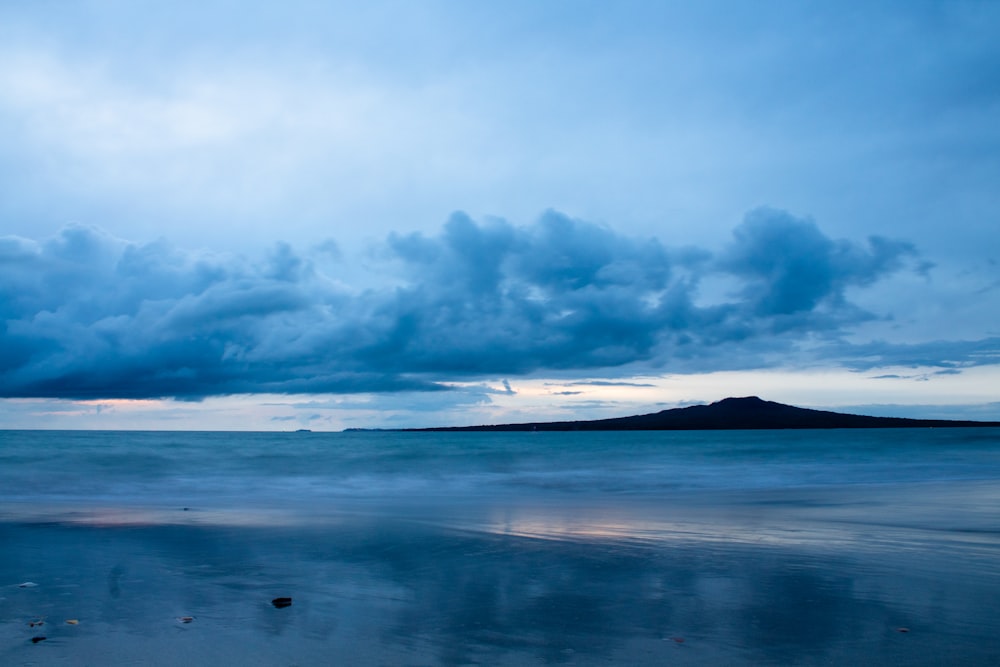 body of water under cloudy sky during daytime