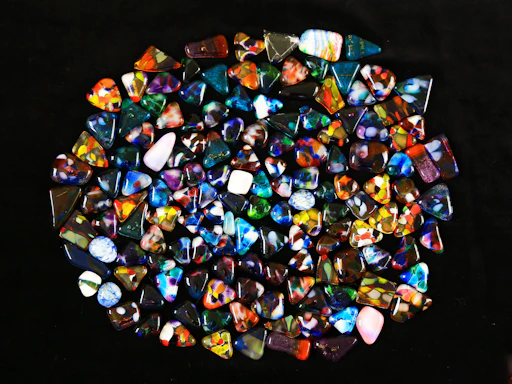 Close-up of sparkling raw gemstones scattered on a wooden table.