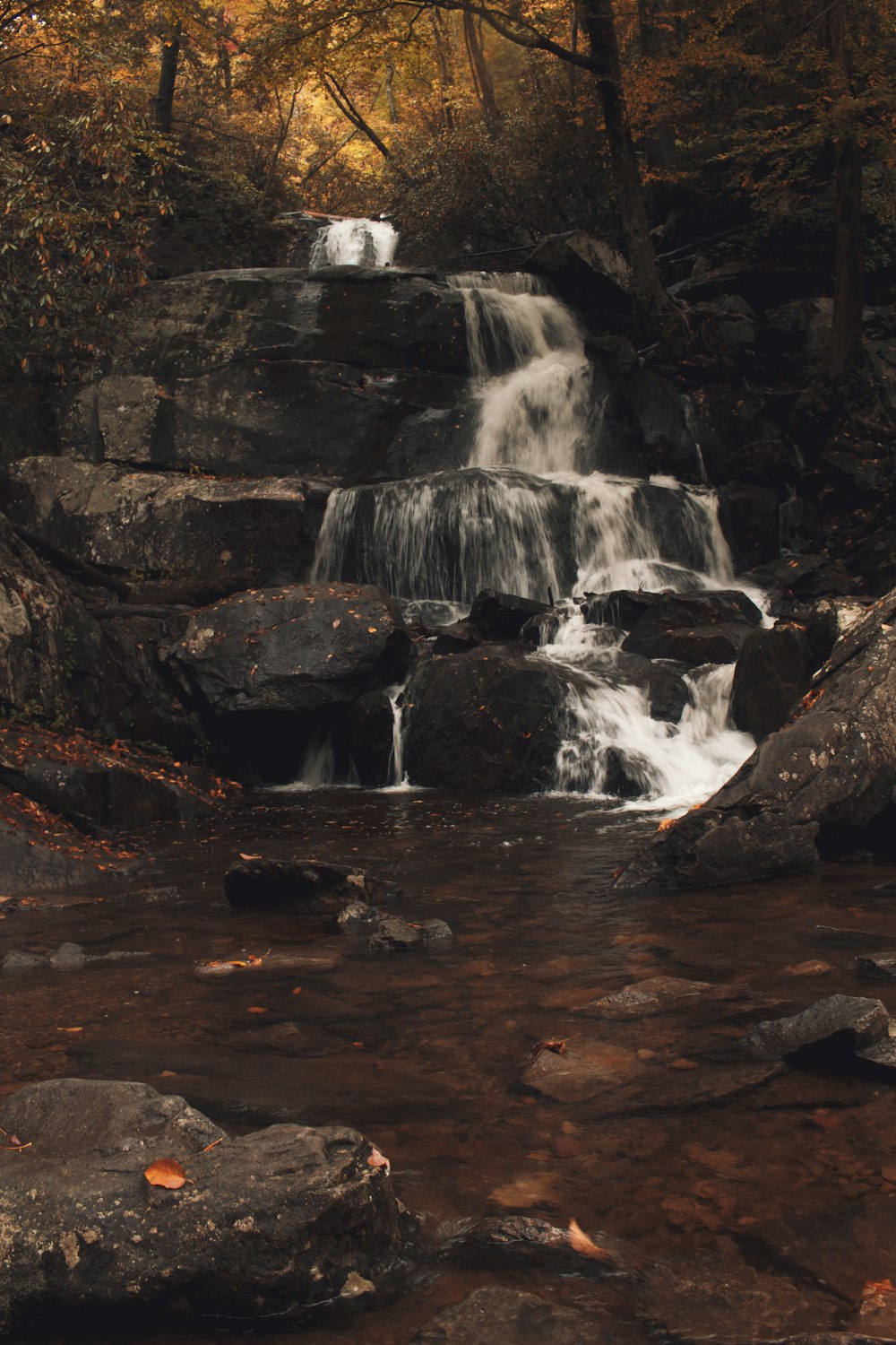 water falls on brown rocky mountain