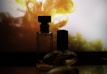 Artistic shot of perfume bottles with swirling purple mist and soft white light
