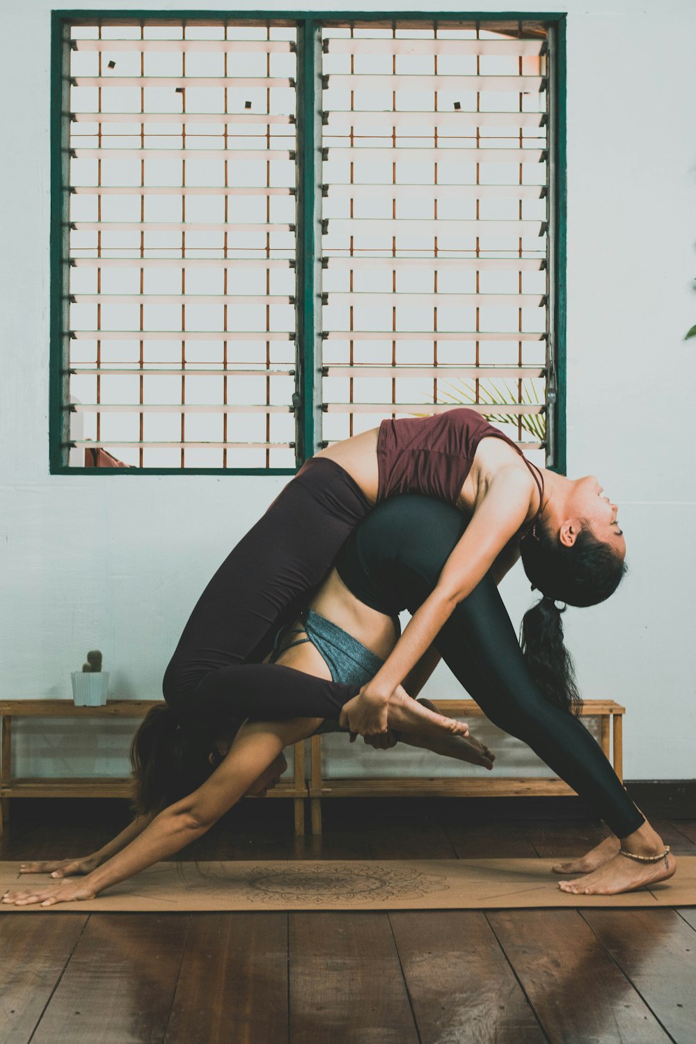 woman in blue tank top and black leggings doing yoga