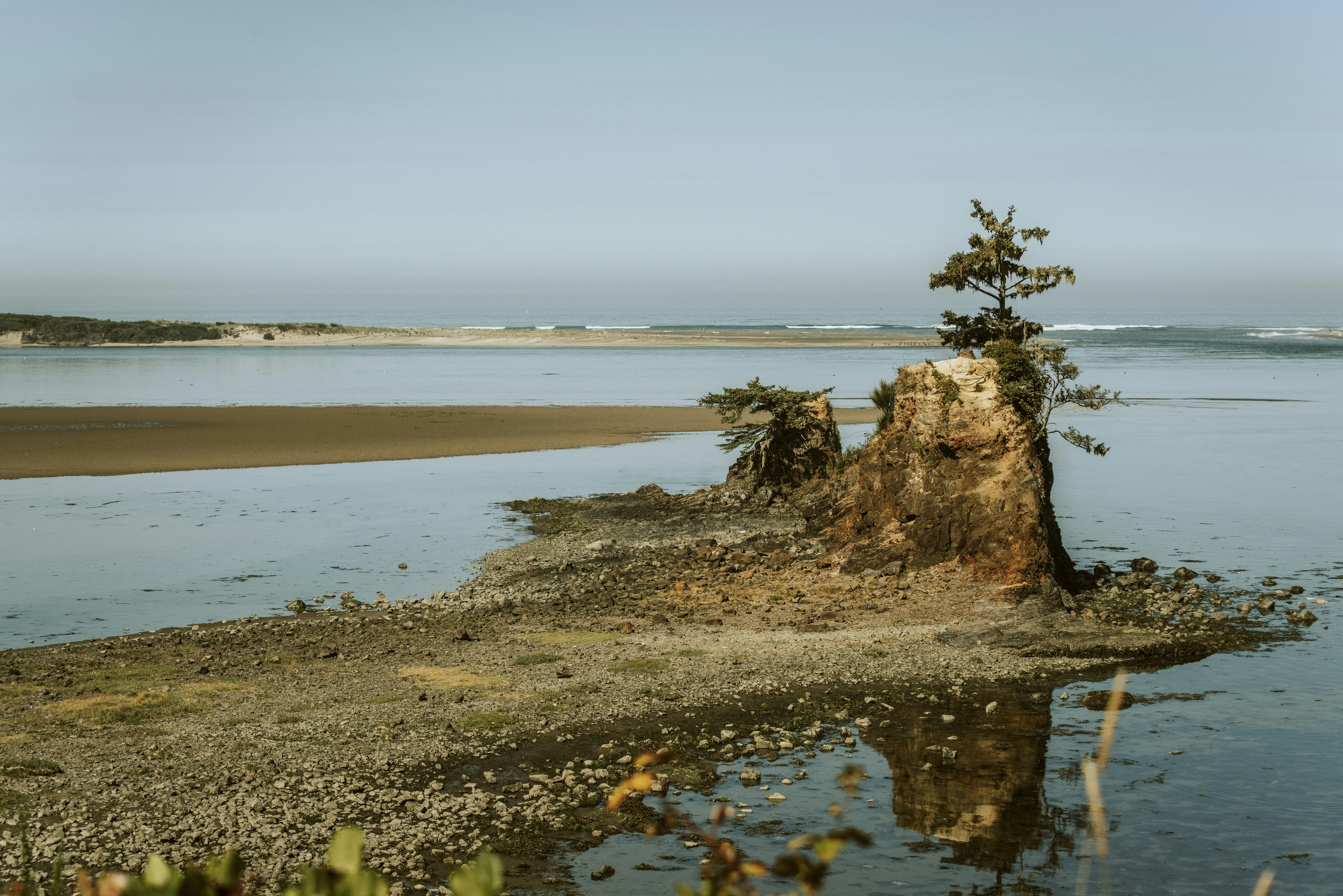 brown rock formation on body of water during daytime