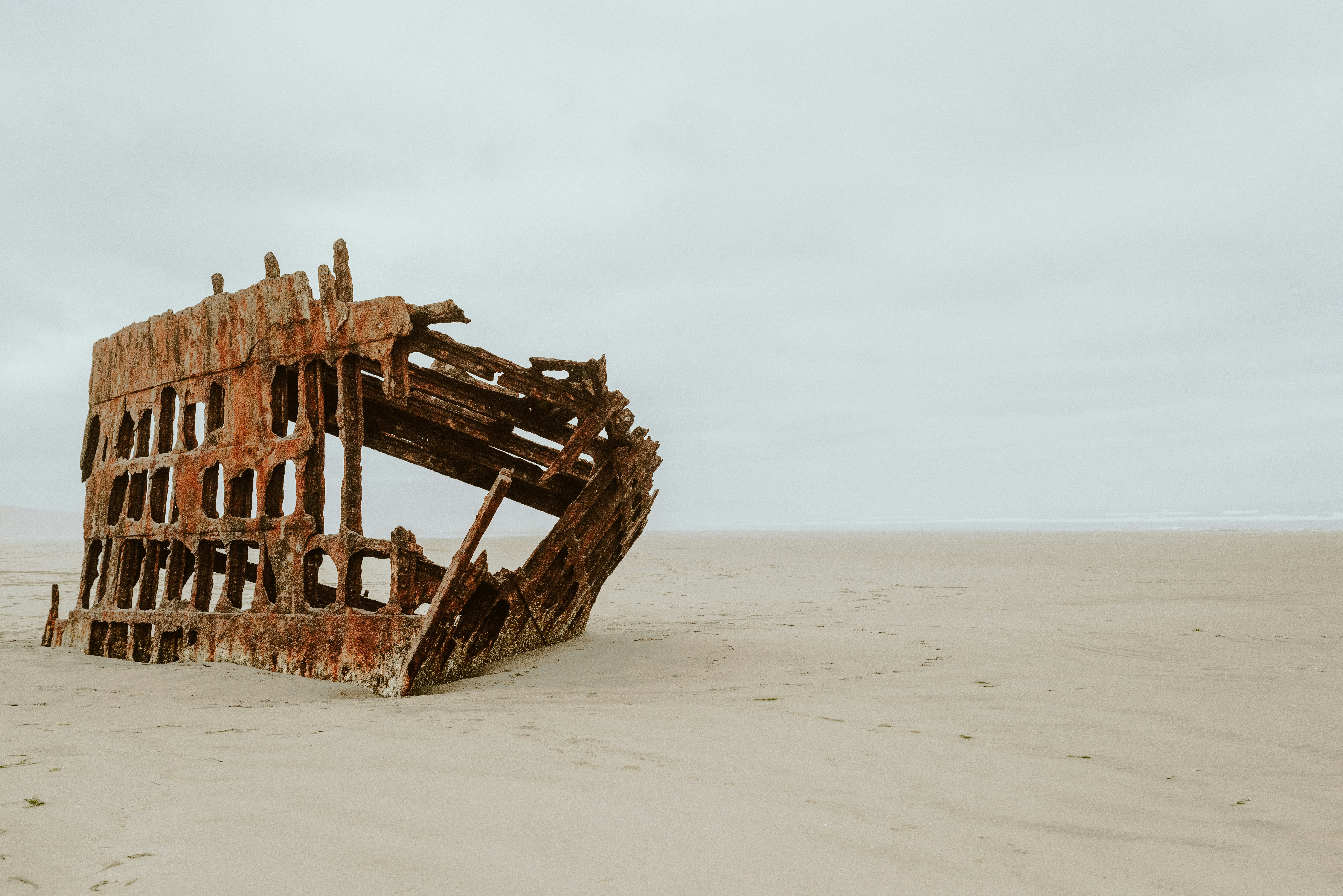 brown wooden ship on white sand during daytime