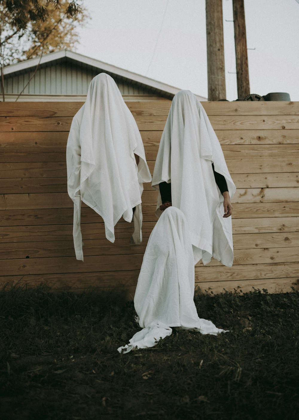 white textile hanged on brown wooden fence