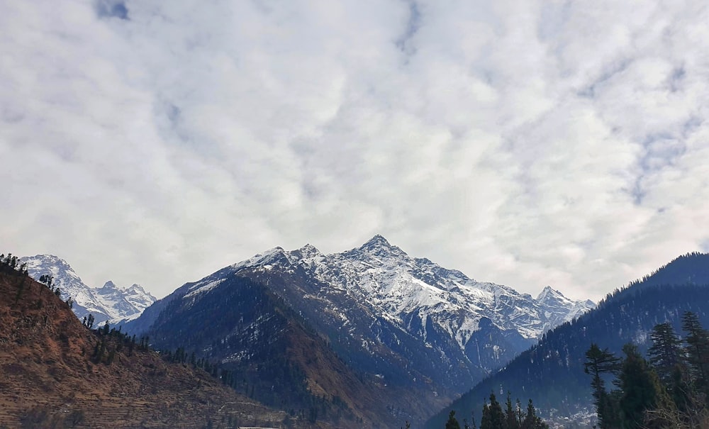 snow covered mountain under cloudy sky during daytime