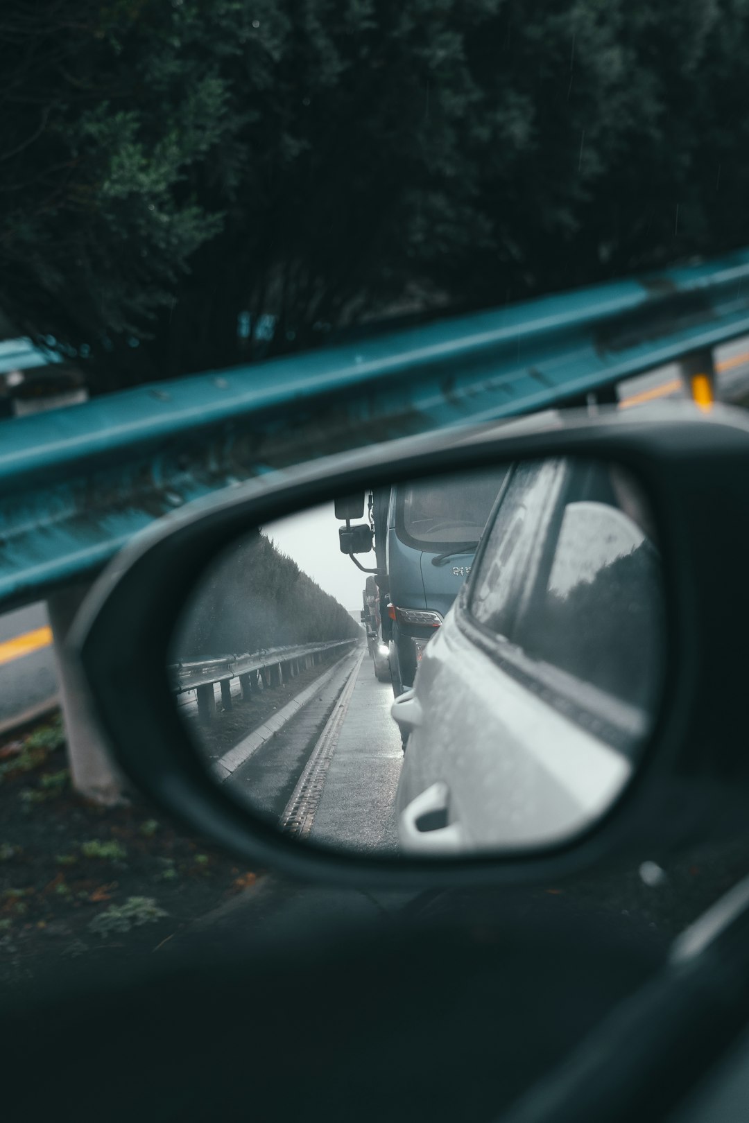 black car side mirror showing black car