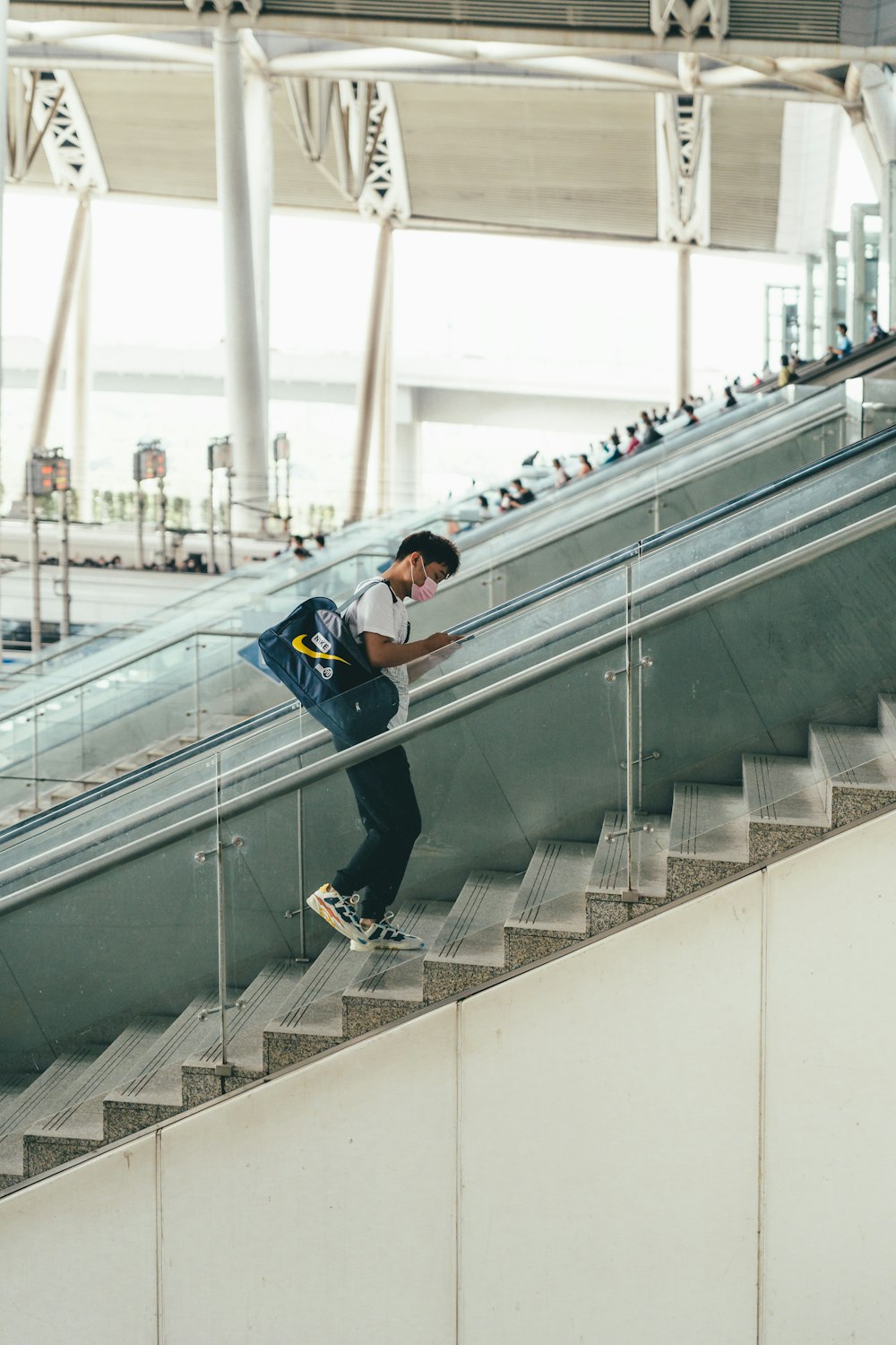 man in blue jacket and black pants on gray concrete staircase