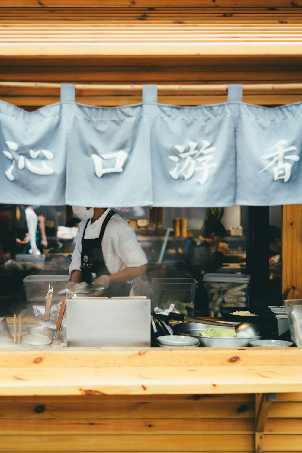 man in white apron standing in front of white table