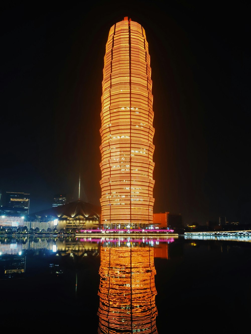 brown high rise building near body of water during night time