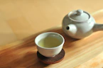 white ceramic teacup on brown wooden table