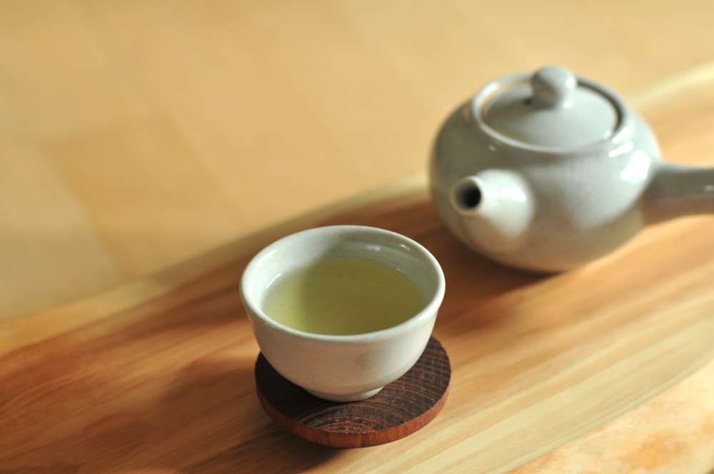 weiße Keramik-Teetasse auf braunem Holztisch