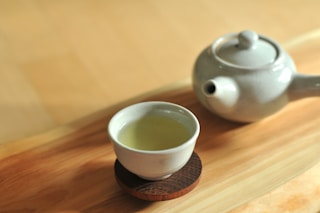 white ceramic teacup on brown wooden table