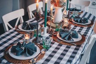 white candles on blue and white checkered table cloth