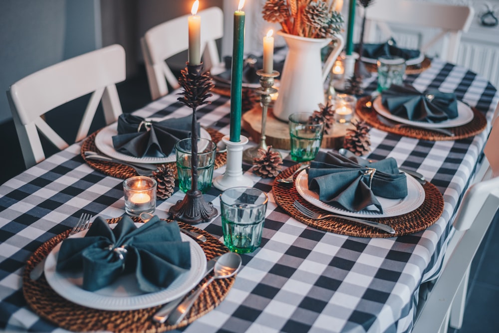 white candles on blue and white checkered table cloth