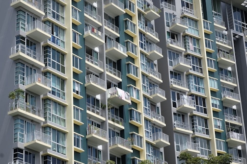 Modern residential building exterior with balconies and large windows.
