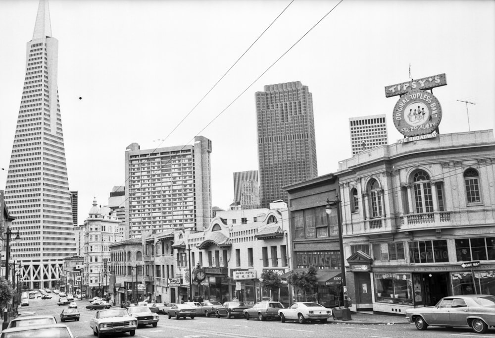 grayscale photo of cars parked near building