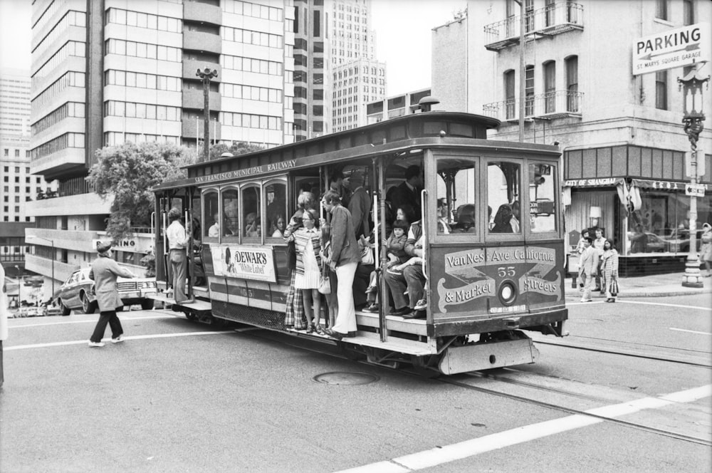 grayscale photo of people riding on tram