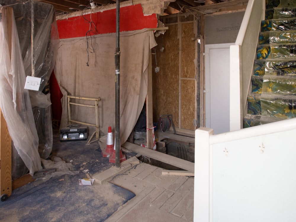 red fire extinguisher beside white wooden cabinet