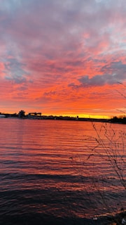 A vibrant sunset reflecting on calm river waters.