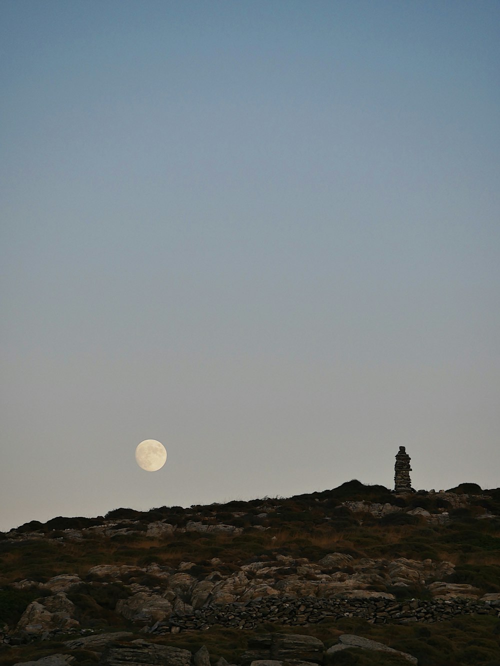 silhouette of person standing on rock formation during night time