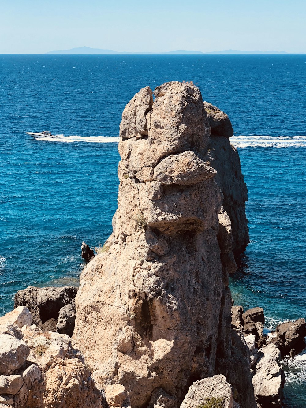 Formazione rocciosa marrone vicino allo specchio d'acqua durante il giorno