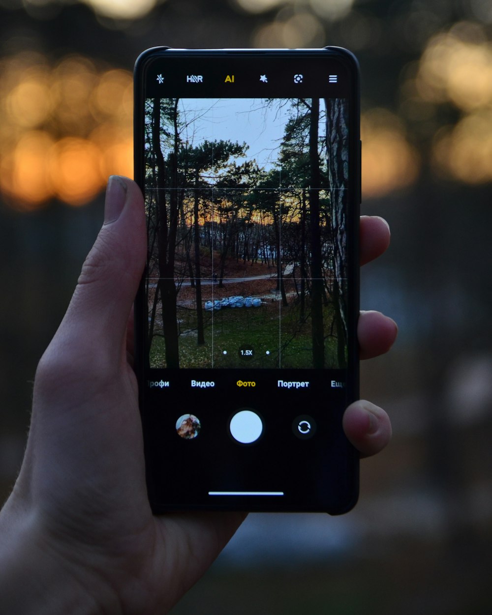 person holding black iphone 4 taking photo of city during sunset