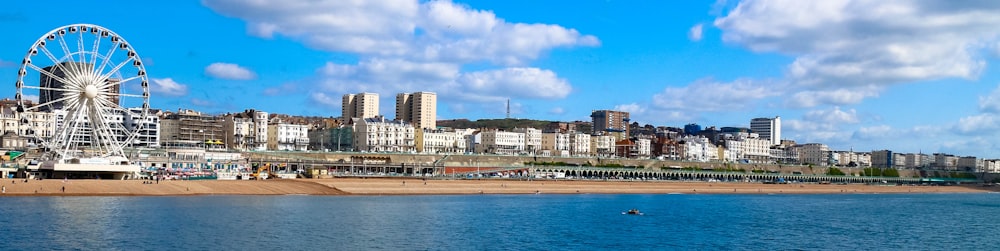 city skyline across blue sea under blue and white cloudy sky during daytime