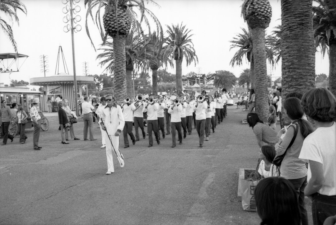 grayscale photo of people sitting on bench near palm trees, California State Fair 1973