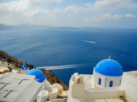 A crisp editorial photo capturing Santorini’s blue domes against a clear sky with minimalist white space framing