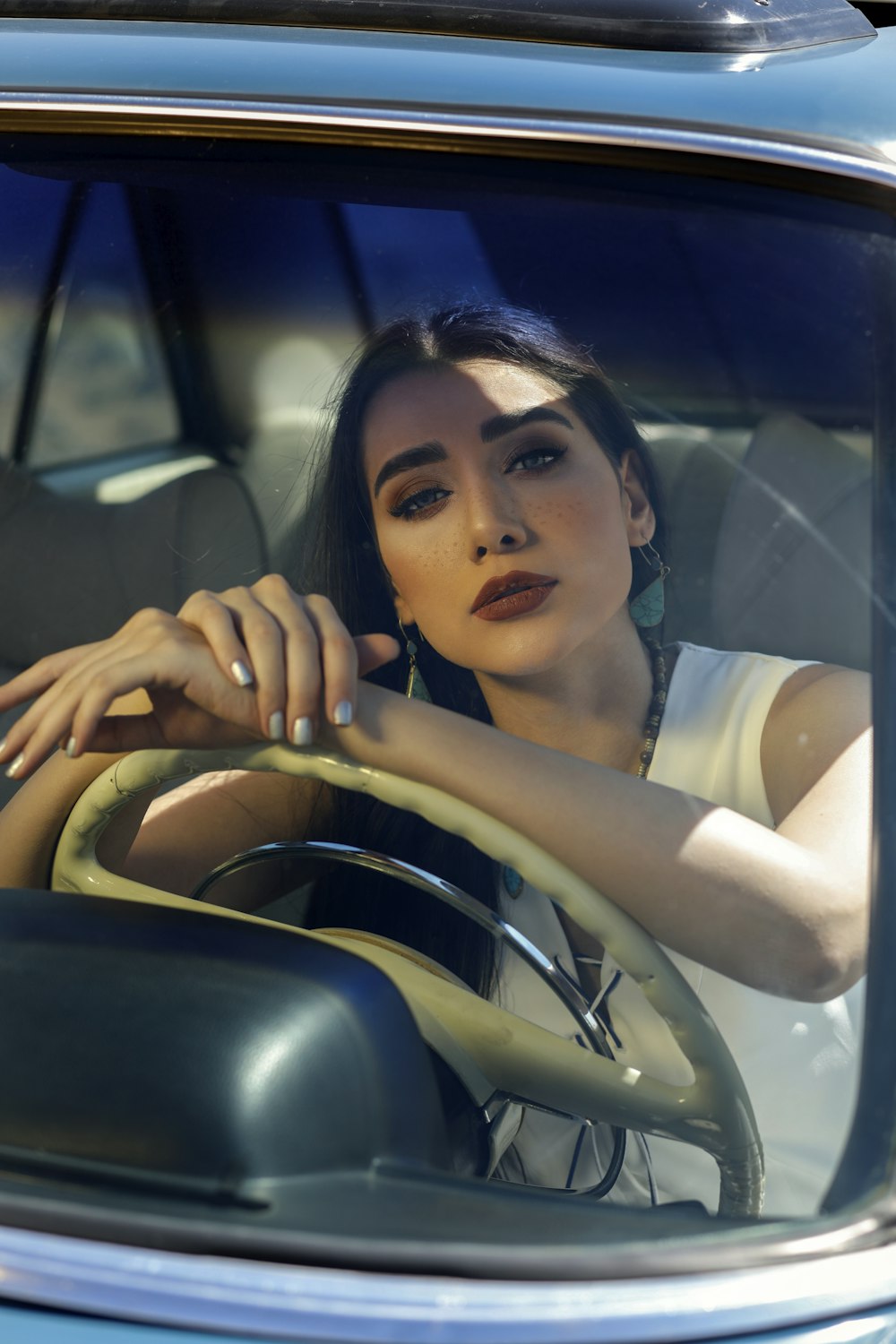 woman in white tank top sitting on car seat