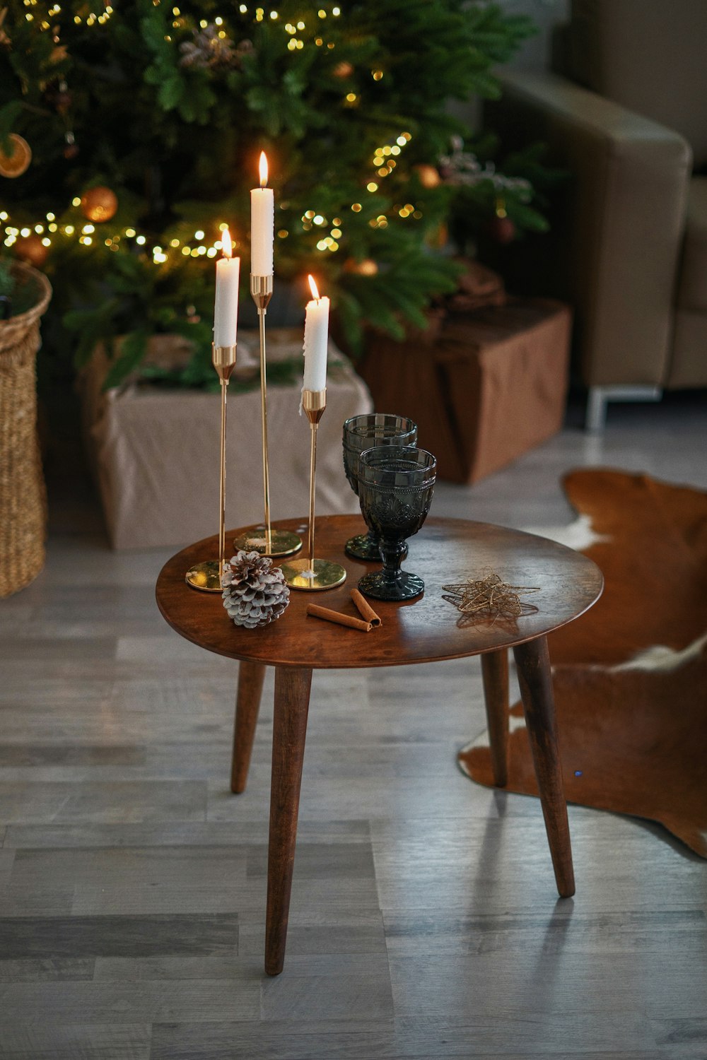 white candles on black ceramic candle holder on brown wooden round table