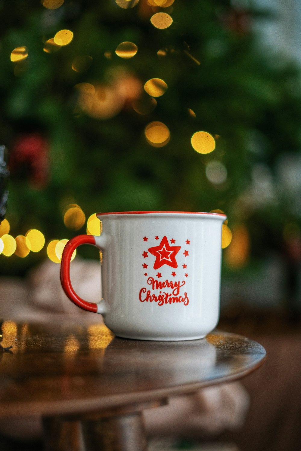 white and red ceramic mug on brown wooden table