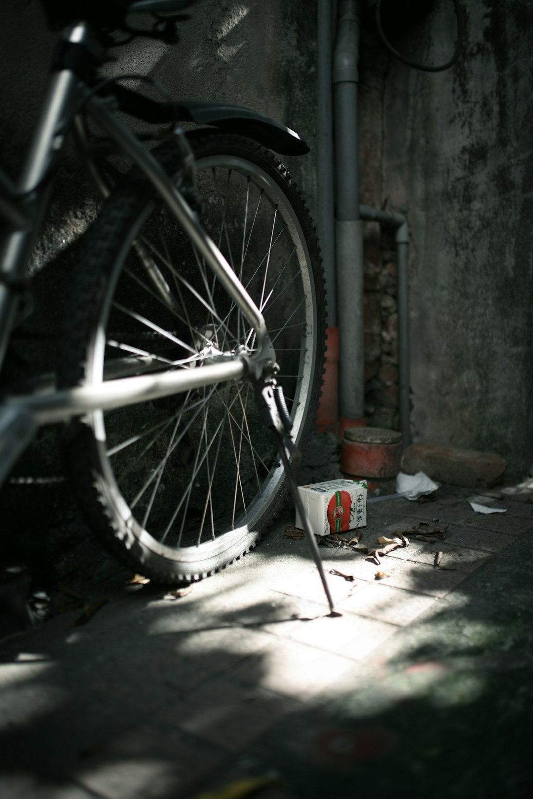 black bicycle wheel leaning on gray wall