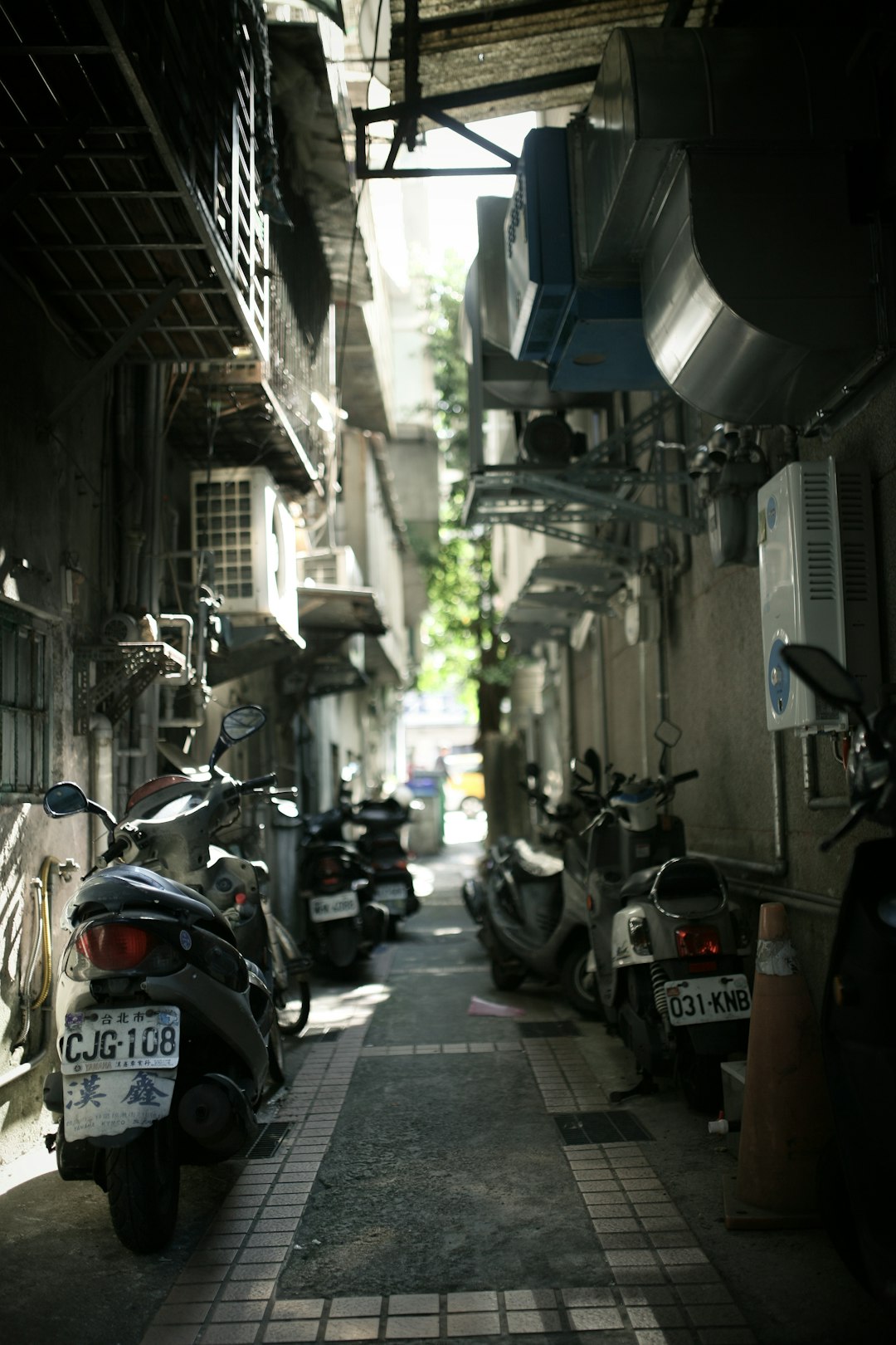 black and white motor scooter parked beside gray concrete building during daytime