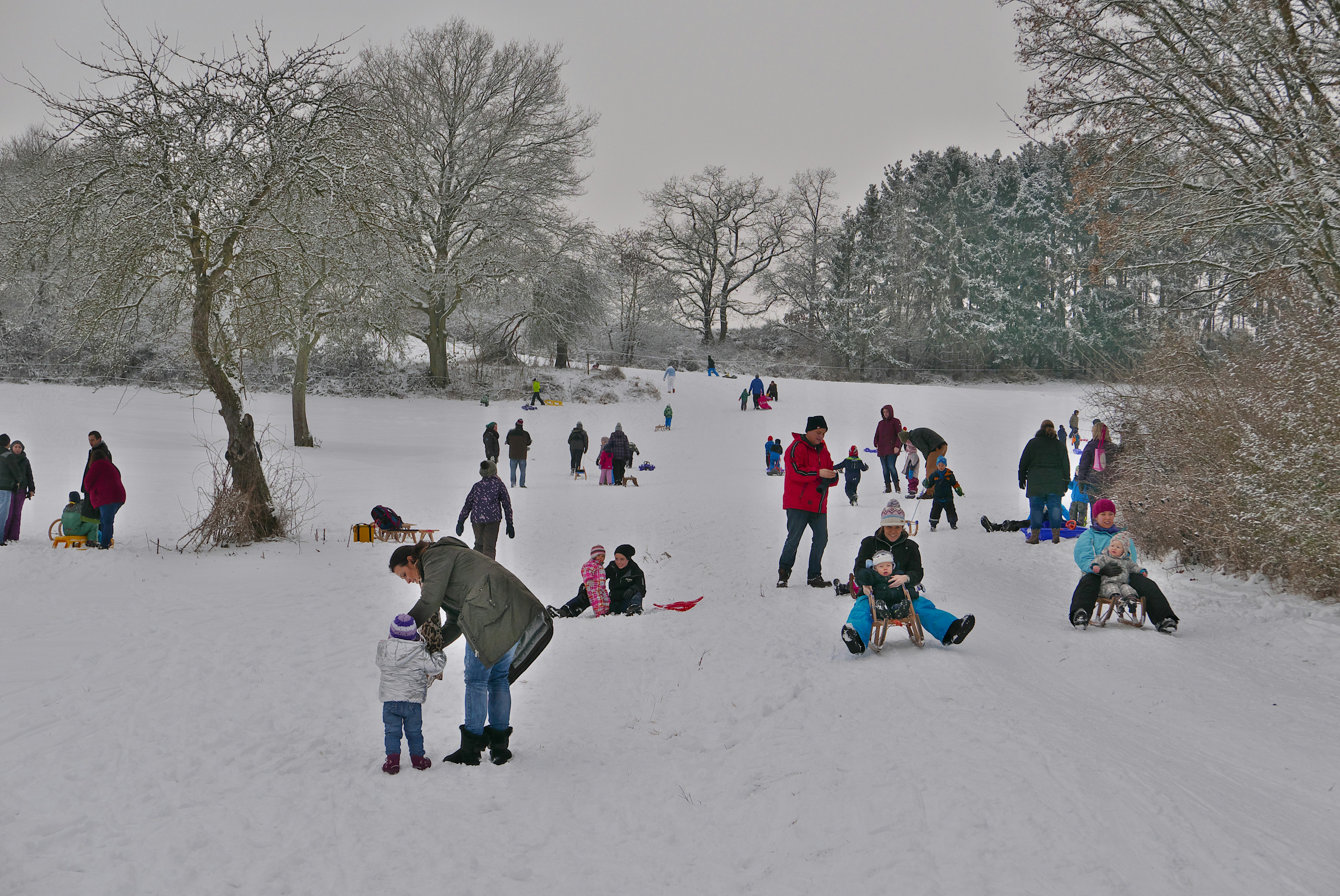 people sitting on snow covered ground during daytime