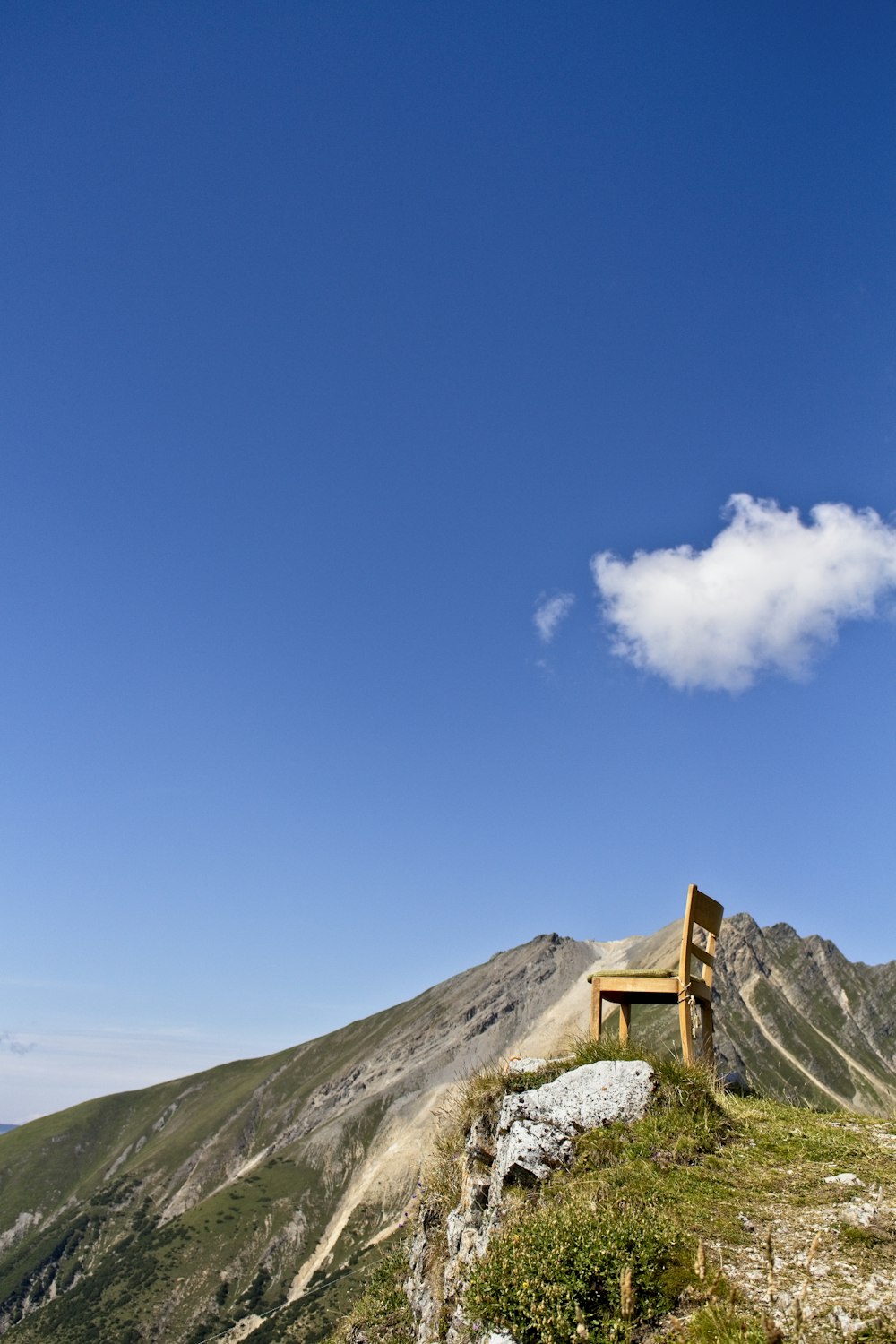 Casa de madera marrón en la cima de la colina bajo el cielo azul y las nubes blancas durante el día